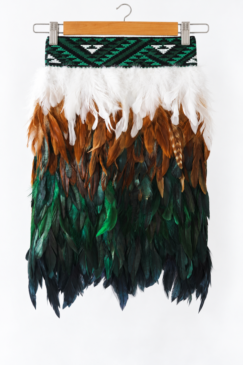 Ngāhere Green kids korowai on a wooden hanger with current green KBH tāniko band against a white background.