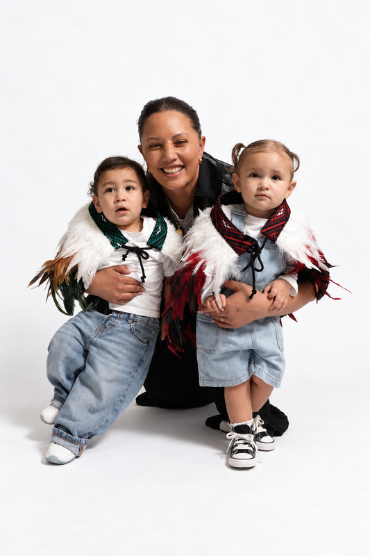 Mother with toddlers wearing Ngāhere Green and Rangatira Red korowai
