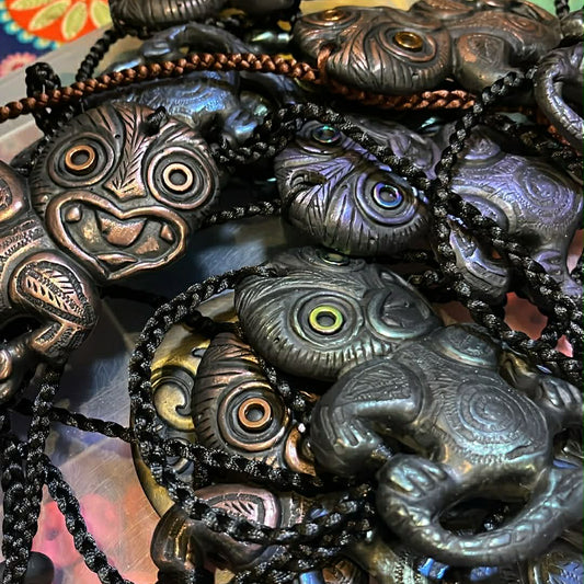 Collection of dark-colored hei tiki necklaces 