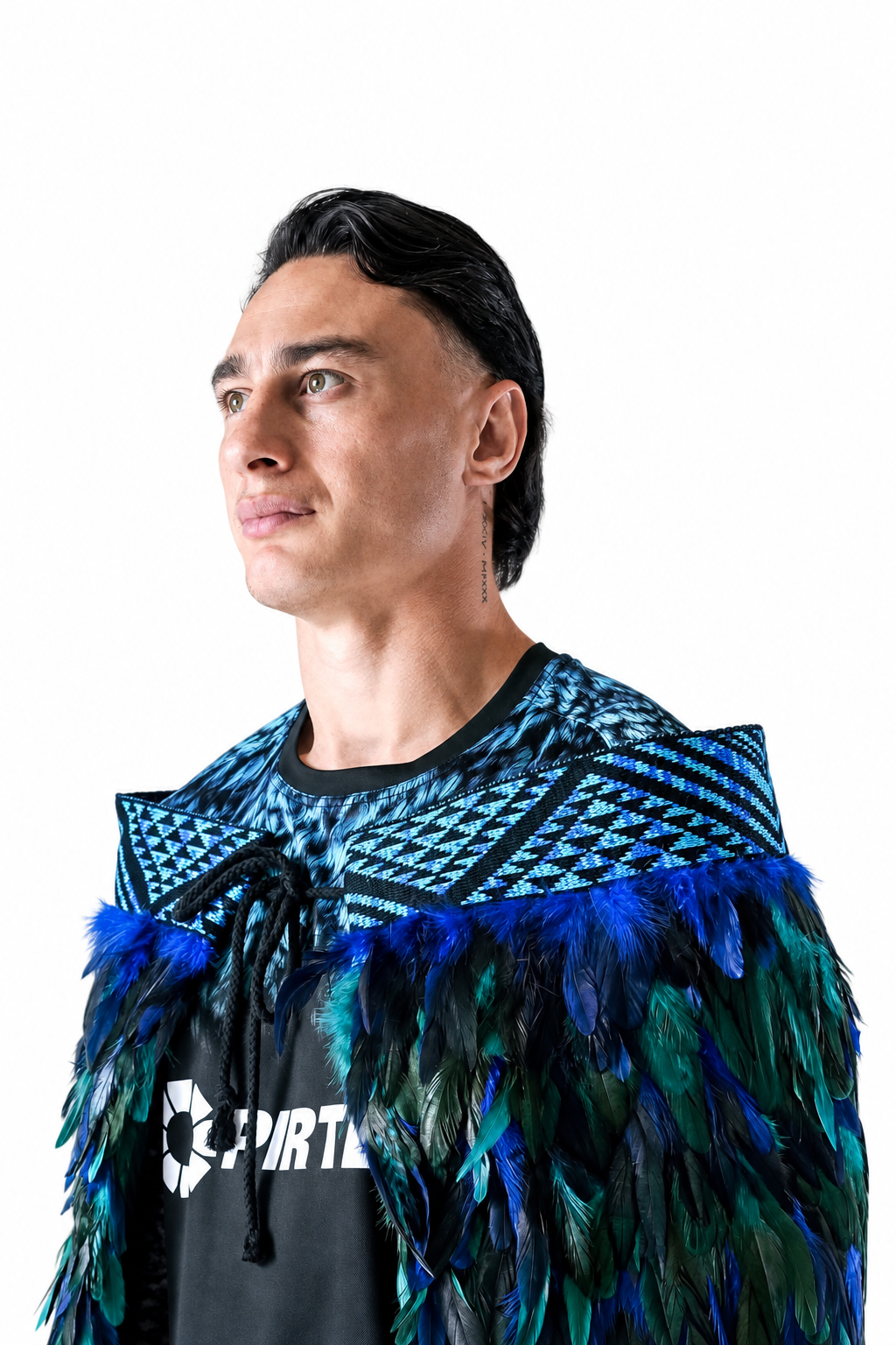 Charnz wearing a custom blue and turquoise korowai, with a close-up of the woven tāniko band against a white background.