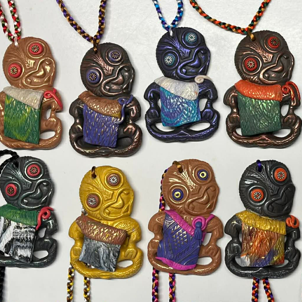 Collection of colorful hei tiki wearng korowai necklaces on a white background