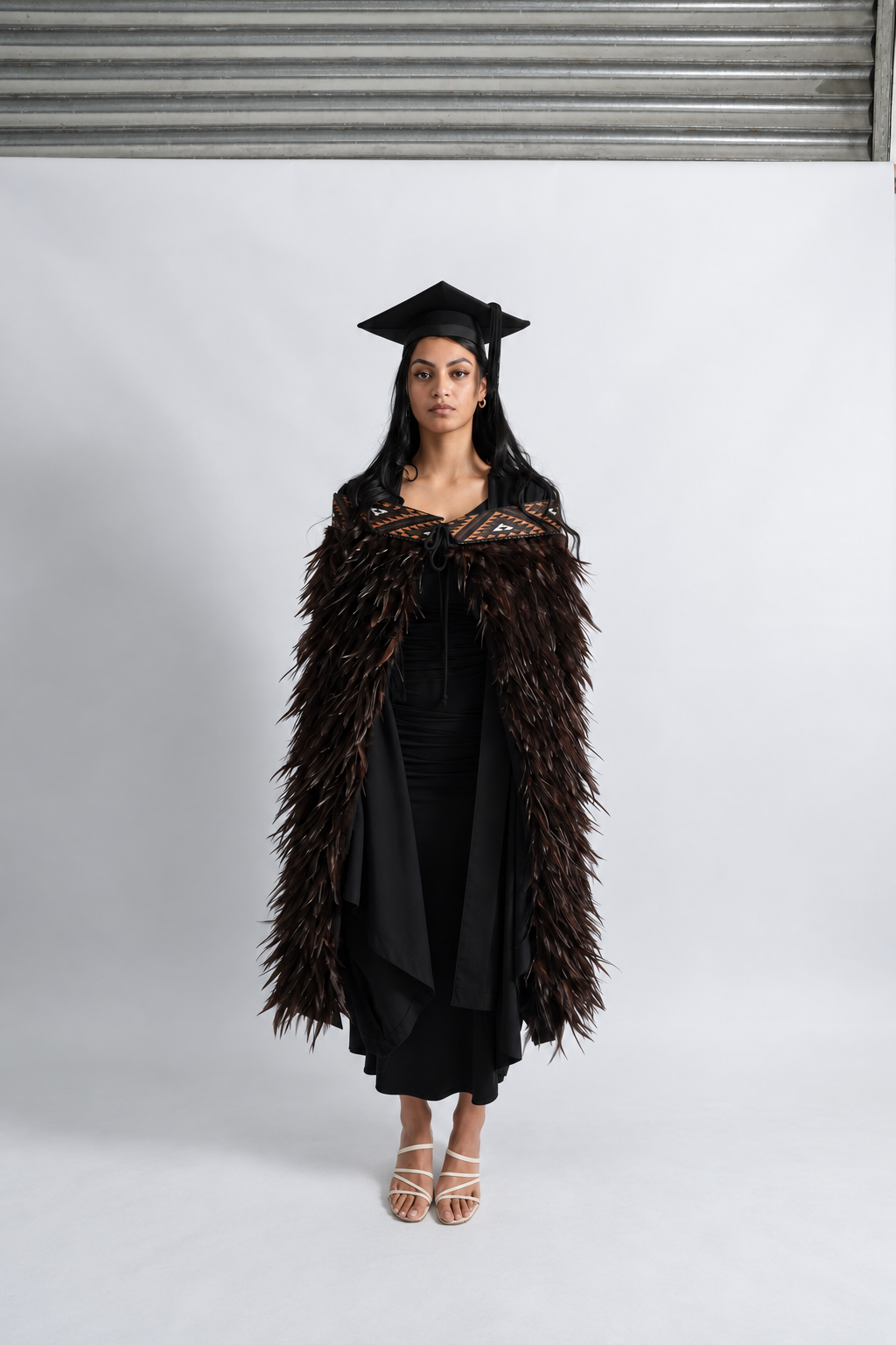 Full-length graduation view of the Kahu Kiwi korowai and its outward-flicking chocolate feathers.