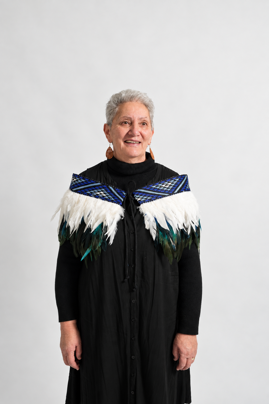 Model smiling while wearing the Moana Blue contemporary adult korowai.