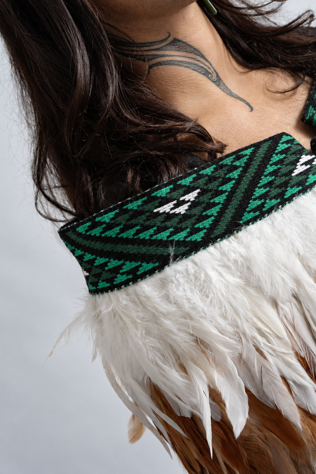 Close-up of Ngāhere Green tāniko and white, brown and green feather layers.