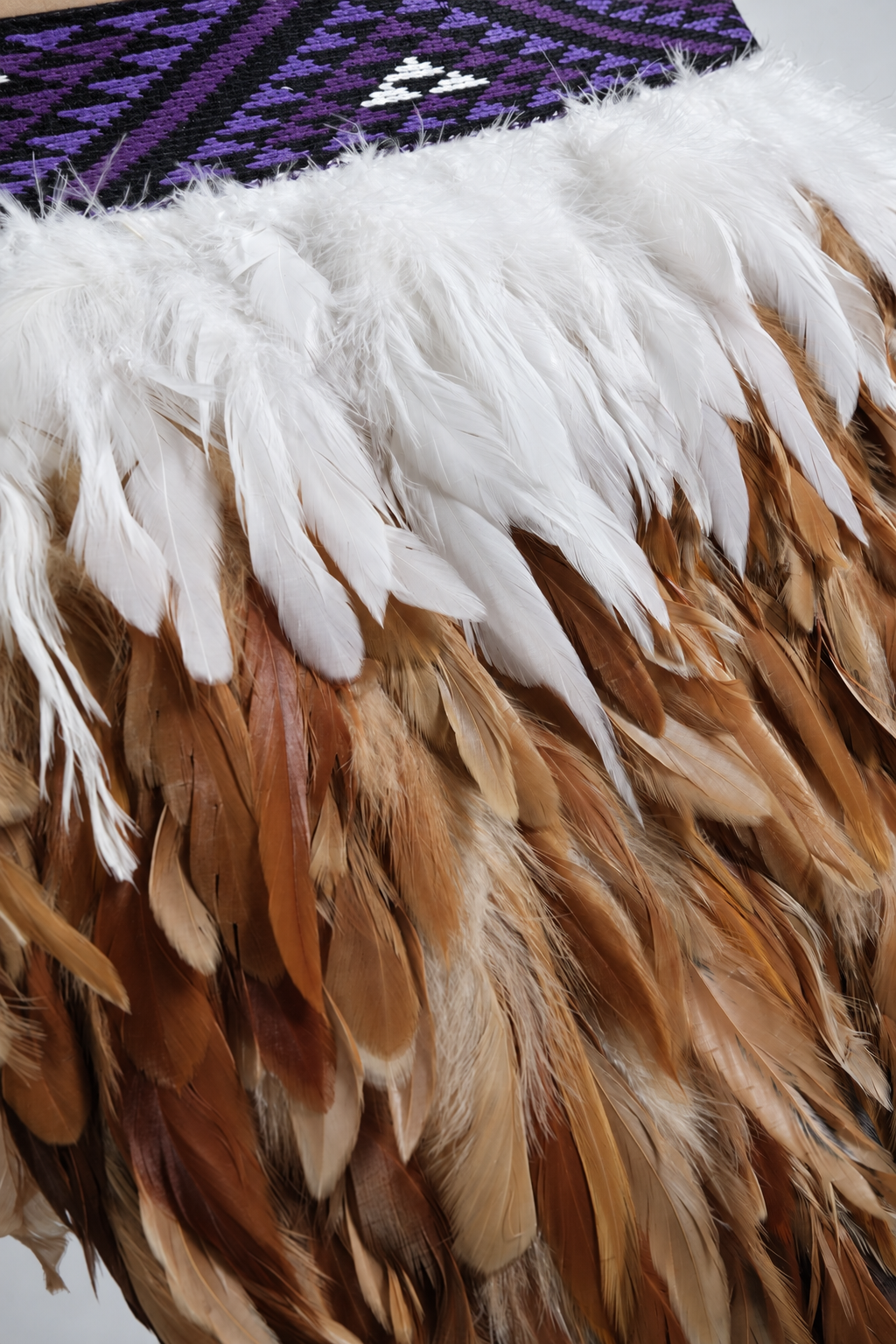 Wairua Purple korowai detail showing soft white and warm brown feather texture