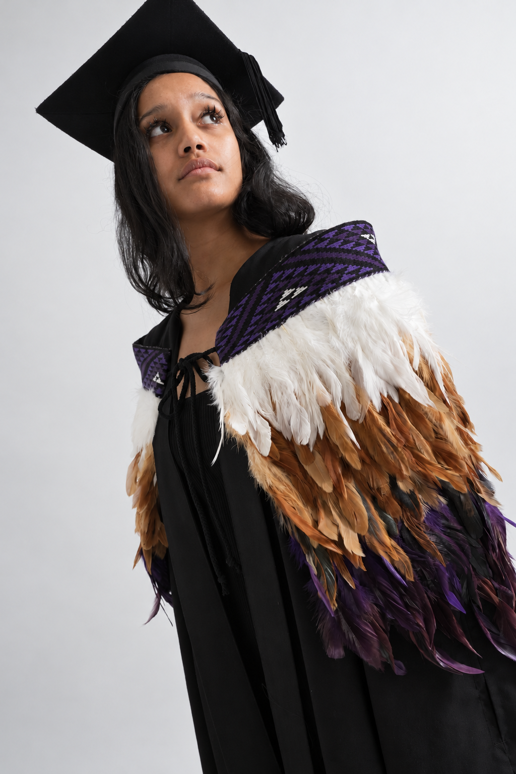 Graduation model wearing Wairua Purple korowai, looking upward