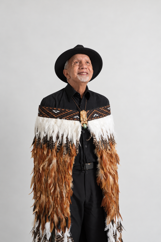 Whenua Brown korowai worn by a smiling model looking upward
