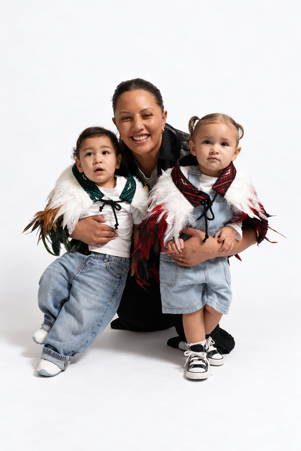Mother with toddlers wearing Ngāhere Green and Rangatira Red korowai