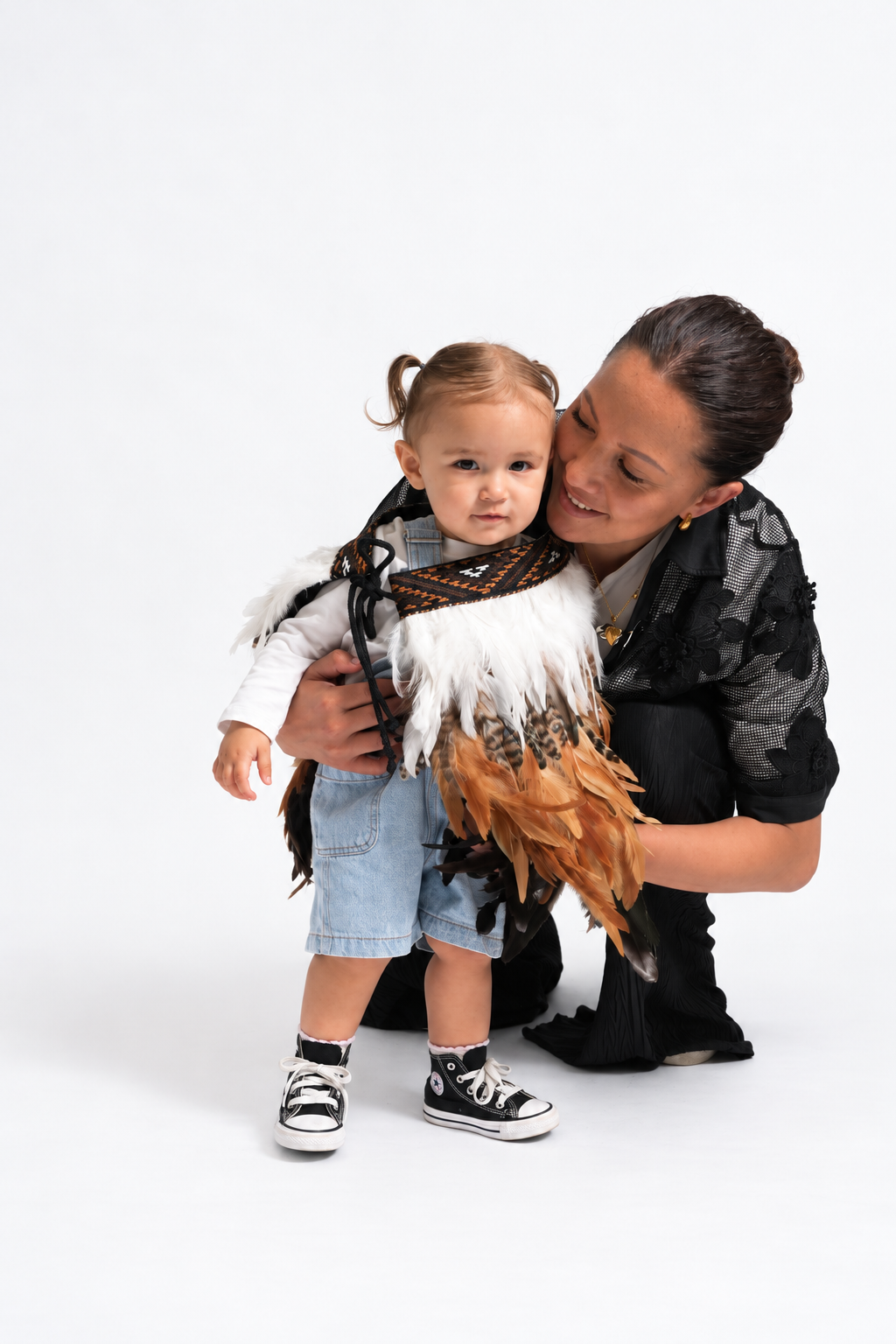Mother beside toddler wearing Whenua Brown korowai
